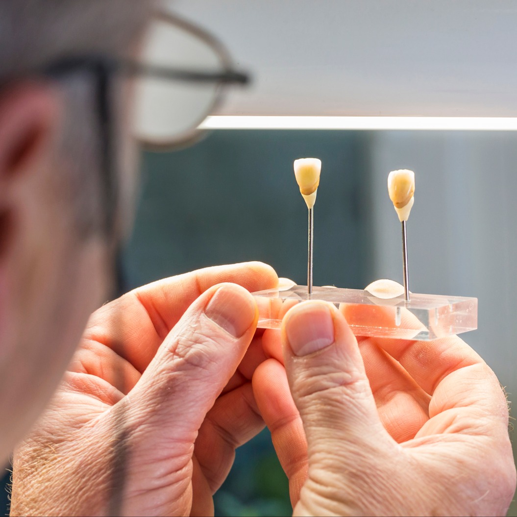 Dentaltechniker begutachtet Zahnersatz