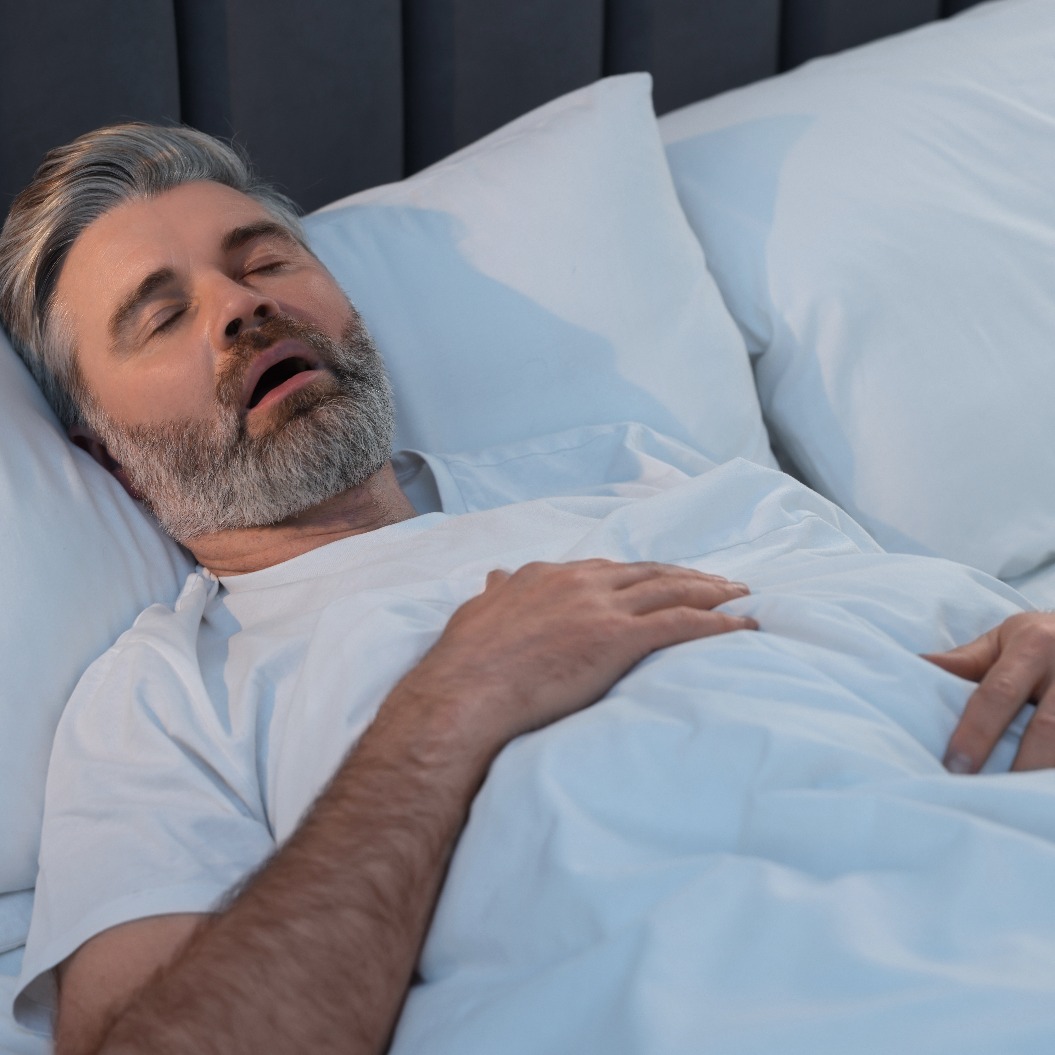 Ein Mann, der zu Hause im Bett schläft und dabei schnarcht